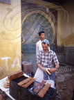 FÈS - la médina : vendeur de brochettes devant une fontaine en zelliges