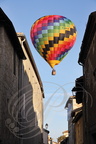 LECTOURE - Rassemblement de montgolfières : montgolfière passant au-dessus d'une rue 