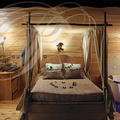 BRASSAC - Les Cabanes perchées : La Cabane "Céleste" (vue générale de l'intérieur : le lavabo, le lit et la baignoire balnéo)