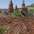 COLLONGES-LA-ROUGE - église Saint-Pierre (à gauche : clocher roman du début du XIe siècle et à droitte : les deux tours défensives) - au premier plan : toiture en tuiles plates