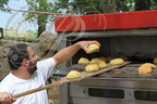 LANNEPAX (32) - le boulanger David Corcagnani enfournant des petits pains au maïs à l'occasion de l'Écofête du Pesqué du 5 juillet 2015 à Perchède (32)