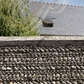 IBOS - maison traditionnelle : mur en galets et lucarne sur une toiture en ardoises typiques 