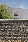 IBOS - maison traditionnelle : mur en galets et lucarne sur une toiture en ardoises typiques 