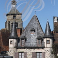 BEAULIEU-SUR-DORDOGNE - place Marbot : maison à tourelles et toiture d'ardoises - au fond : la tour de l'église Saint-Pierre