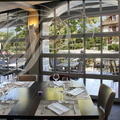 BEAULIEU-SUR-DORDOGNE -  restaurant "Les Flots Bleus" : salle du restaurant avec la vue sur la place du Monturu et la Dordogne