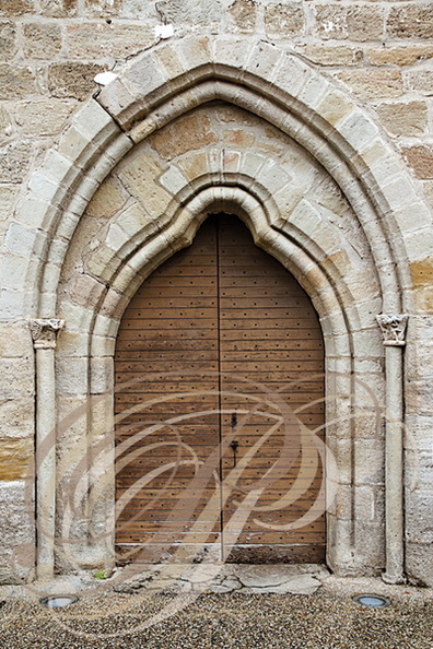 LA CHAPELLE-AUX-SAINTS - église Saint-Namphaise (XIIe siècle) : portail trilobé dans un arc brisé prolongé par deux colonnettes à chapiteaux sculptés