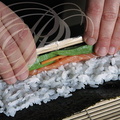 Fabrication d'un MAKI SUSHI (avocat, carotte et saumon) : enroulage Fabrication d'un MAKI (avocat, carotte et saumon) par Hélène Reberga ("BAGUETTE ET SUSHI") 