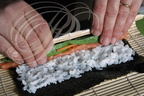 Fabrication d'un MAKI SUSHI (avocat, carotte et saumon) : enroulage Fabrication d'un MAKI (avocat, carotte et saumon) par Hélène Reberga ("BAGUETTE ET SUSHI") 