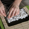 Fabrication d'un MAKI SUSHI : étalage du riz sur la feuille d'algue par Hélène Reberga ("BAGUETTE ET SUSHI") 