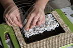 Fabrication d'un MAKI SUSHI : étalage du riz sur la feuille d'algue par Hélène Reberga ("BAGUETTE ET SUSHI") 
