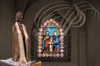 NAJAC - église Saint-Barthélémy : le vitrail et la statue en bois sculpté de saint Barthélémy
