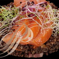 SAUMON d'Écosse Label Rouge fumé sur un lit de lentilles Beluga cuites avec des carottes, des algues Kombu et des lardons fumé et décoré de germes de radis, poireaux et alfalfa