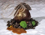 Mascarpone laqué chocolat saupoudré de poudre dorée sur un nid de brunoise de truffe noire, sirop café noisette par Jérôme Burel